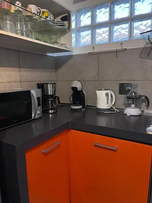 a kitchen with an orange and black counter top at Farnesina Rooftop Terrace in Rome