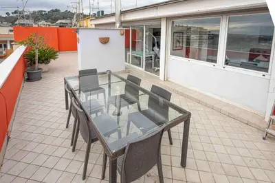 a glass table and chairs on a balcony at Farnesina Rooftop Terrace in Rome