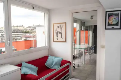 a small room with a window and a red couch at Farnesina Rooftop Terrace in Rome