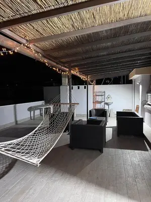 a hammock in a room with chairs and a table at Farnesina Rooftop Terrace in Rome