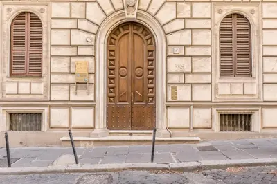 a building with a wooden door and two windows at Roman Holiday Repubblica in Rome