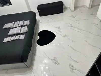 a white marble floor with a black couch and a table at IMPERIAL suite COLOSSEUM in Rome