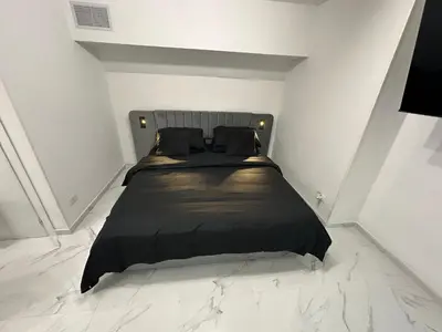 a bedroom with a black bed in a white room at IMPERIAL suite COLOSSEUM in Rome