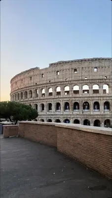 a large building with a brick wall in front of it at IMPERIAL suite COLOSSEUM in Rome