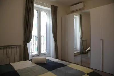 a bedroom with a bed and a large window at MGFCandia111 - Appartamento al Vaticano in Rome