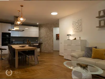 a living room and kitchen with a couch and a table at DeaSuites One in Rome