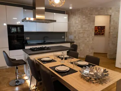 a kitchen with a wooden table with chairs and a stove at DeaSuites One in Rome