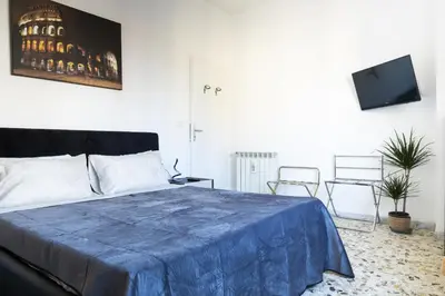 a bedroom with a blue blanket on a bed at The Roma Flat- private parking & direct bus to Vatican City in Rome