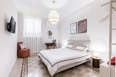 a white bedroom with a bed and a tv at Rome Golden Retreat in Rome