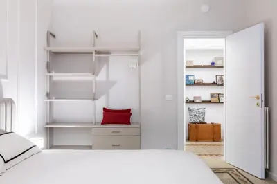 a bedroom with a white bed and a red pillow at Rome Golden Retreat in Rome