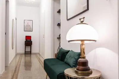 a living room with a green couch and a lamp at Rome Golden Retreat in Rome