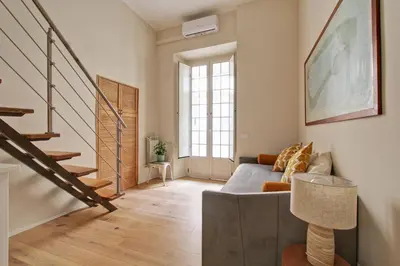 a living room with a couch and a staircase at Boncompagni79 design & comfort in the City Center Villa Borghese in Rome