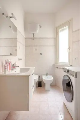 a bathroom with a toilet sink and a washing machine at Francis house in Rome