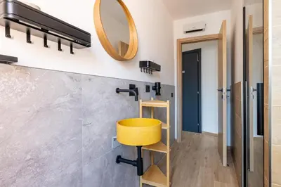 a bathroom with a yellow stool and a mirror at cRoma - guest house in Rome