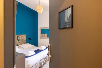 a bedroom with a bed with a blue wall at cRoma - guest house in Rome