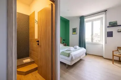 a bedroom with a bed and a bathroom with a window at cRoma - guest house in Rome
