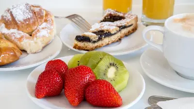 a table with plates of fruit and a cup of coffee at Princeps Boutique Hotel in Rome