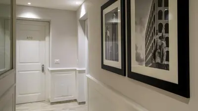 a hallway with a white door and framed pictures at Princeps Boutique Hotel in Rome