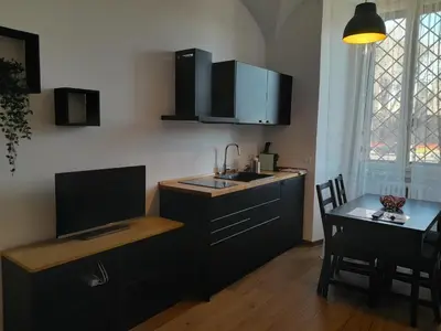 a kitchen with a sink and a desk with a table at Acche Apartments in Rome