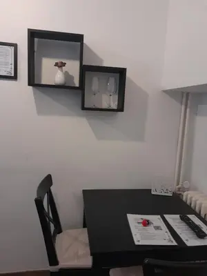 a black table and chair with a mirror on the wall at Acche Apartments in Rome