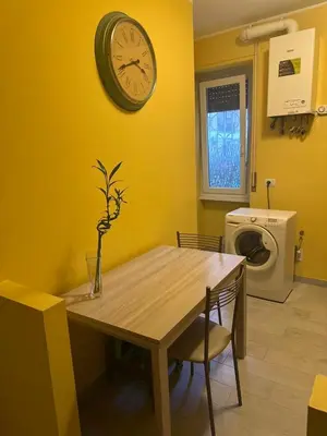a dining room with a table and a clock on the wall at Sunflower Rome in Rome