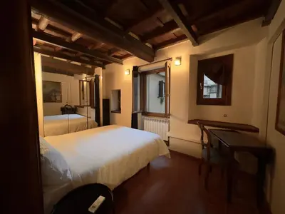 a bedroom with two beds and a table and a window at Casa dolce Casa Trastevere in Rome