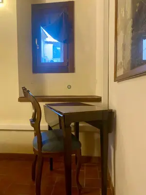 a wooden table with a chair and a desk with a mirror at Casa dolce Casa Trastevere in Rome