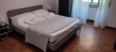 a bedroom with a large bed with white sheets at Casa Cartoni in Rome