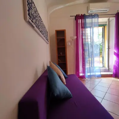 a purple bed in a room with a window at Casa Cartoni in Rome