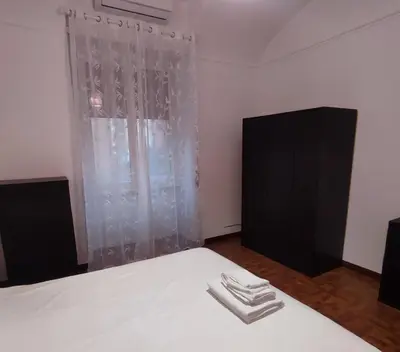 a bedroom with a bed with white sheets and a window at Casa Cartoni in Rome