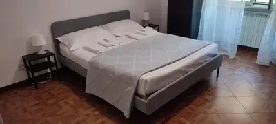 a bedroom with a large bed with white sheets at Casa Cartoni in Rome