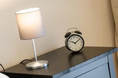 an alarm clock sitting on a table next to a lamp at Vaticano Appartamento Suite Roma Centro Aura D1 in Rome