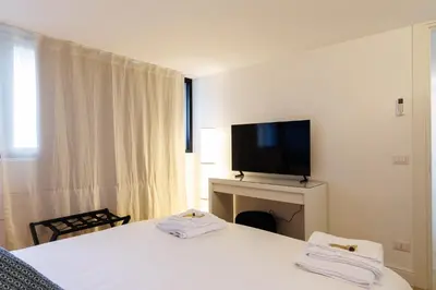 a hotel room with two beds and a flat screen tv at Vaticano Appartamento Suite Roma Centro Aura D1 in Rome