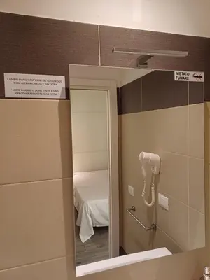 a mirror in a bathroom with a bed in a room at Room and Apartment Rome in Rome