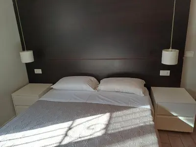 a bed with two white pillows and two night stands at Room and Apartment Rome in Rome