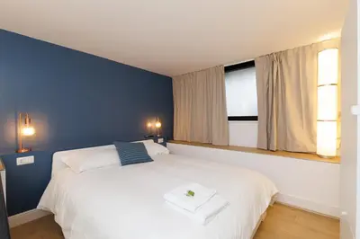a bedroom with a large white bed with blue walls at Vaticano Appartamento Suite Roma Centro Aura D4 in Rome