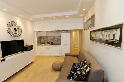 a living room with a couch and a clock on a wall at Vaticano Appartamento Suite Roma Centro Aura D4 in Rome