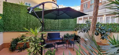 a patio with a chair and an umbrella at OASI - Vaticano 3Clima Netflix Wi-Fi Parking Garden in Rome