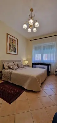 a bedroom with a large bed and a chandelier at OASI - Vaticano 3Clima Netflix Wi-Fi Parking Garden in Rome