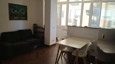 a living room with a couch and a table at Appartamento moderno con vista sul verde 2 fermate da San Pietro in Rome