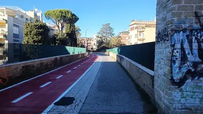 an empty street with graffiti on a wall at Appartamento moderno con vista sul verde 2 fermate da San Pietro in Rome
