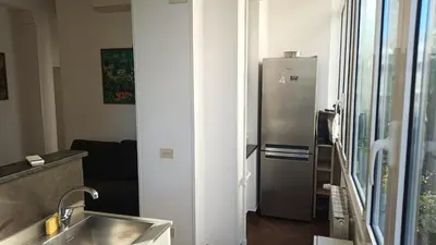 a kitchen with a stainless steel refrigerator next to a window at Appartamento moderno con vista sul verde 2 fermate da San Pietro in Rome