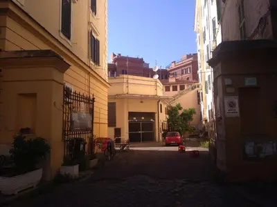 an alley with buildings and a red car in the distance at YourStay@Rome Vatican in Rome