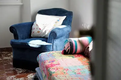 a blue chair with a pillow sitting next to ainylinylinylinylinylinyl at Heartwarming Apartment in ROMA - 5 Minutes from Colosseum in Rome