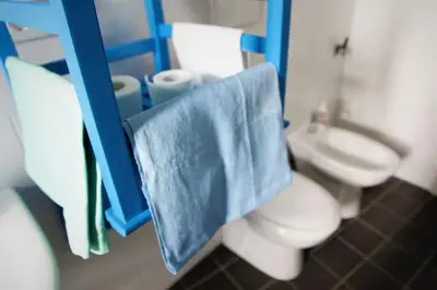 a bathroom with a toilet and a blue towel at Heartwarming Apartment in ROMA - 5 Minutes from Colosseum in Rome