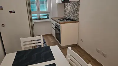 a kitchen with a table and chairs and a stove at La casa di Lele in Rome