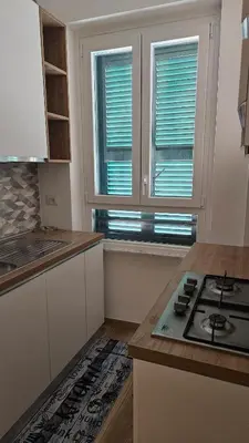 a kitchen with a stove and two windows at La casa di Lele in Rome
