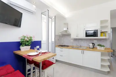 a kitchen with white cabinets and a wooden counter top at Bright Vatican 2 bedroom Apartment in Rome