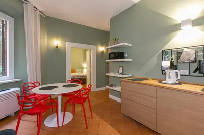 a kitchen with a table and red chairs in a room at Home Baccina 28 in Rome