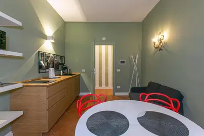 a living room with a table and red chairs at Home Baccina 28 in Rome